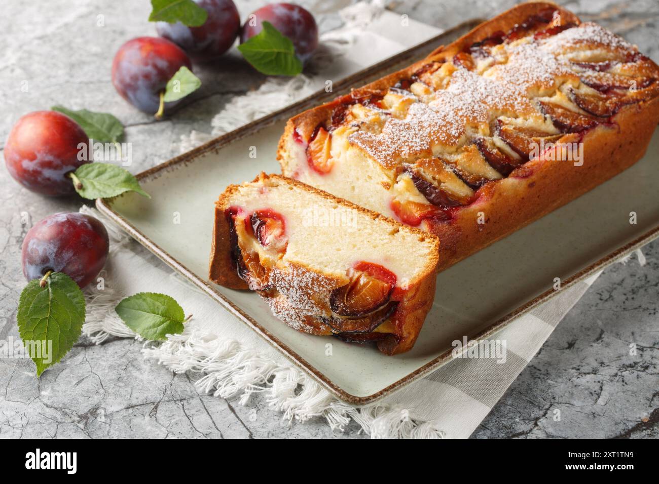 Fresh Plum Cake with yogurt and olive oil, the sponge is moist and flavourful closeup on the plate on the table. Horizontal Stock Photo