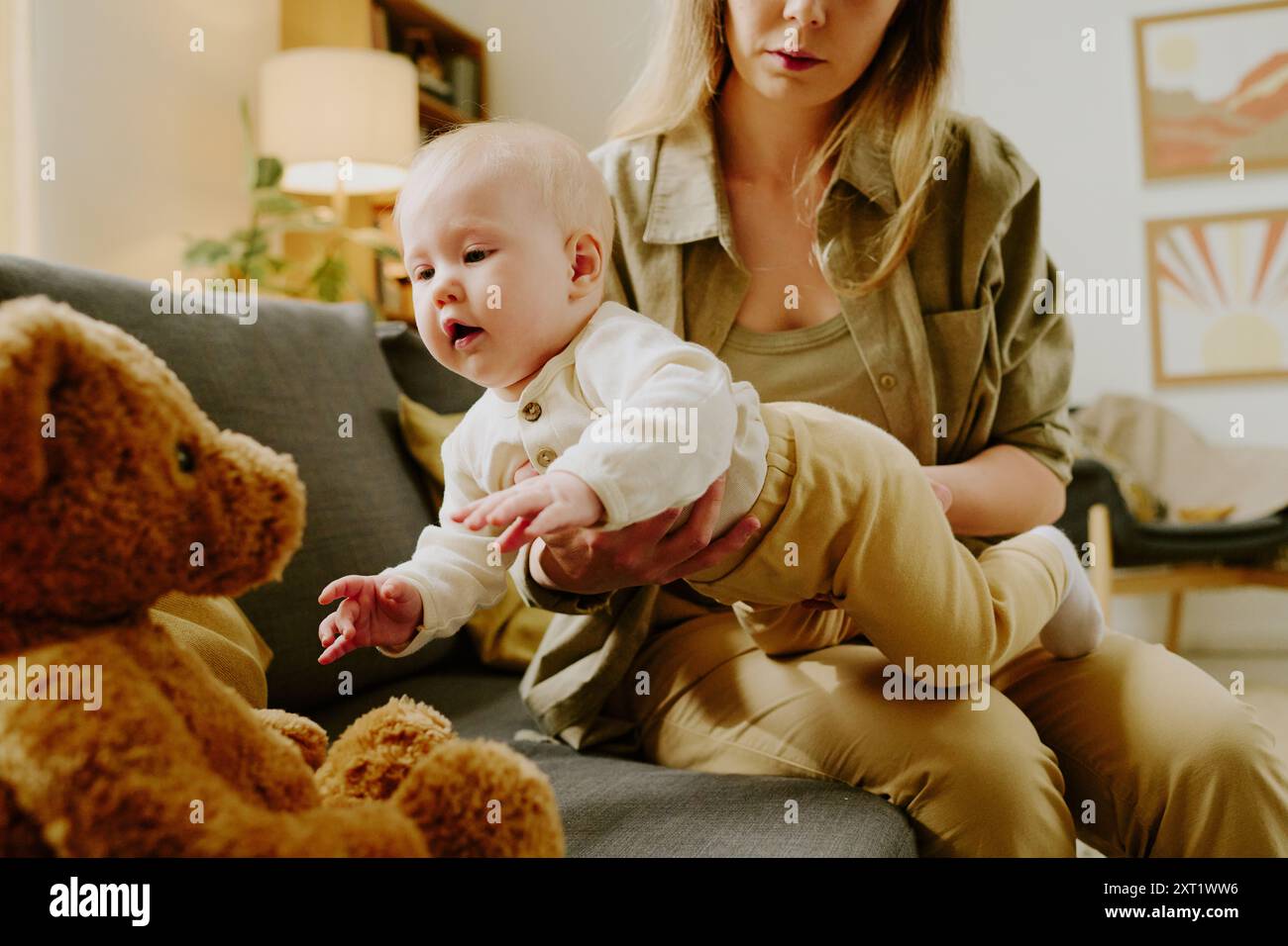 Holding Baby and Looking at Teddy Bear in Living Room Stock Photo - Alamy