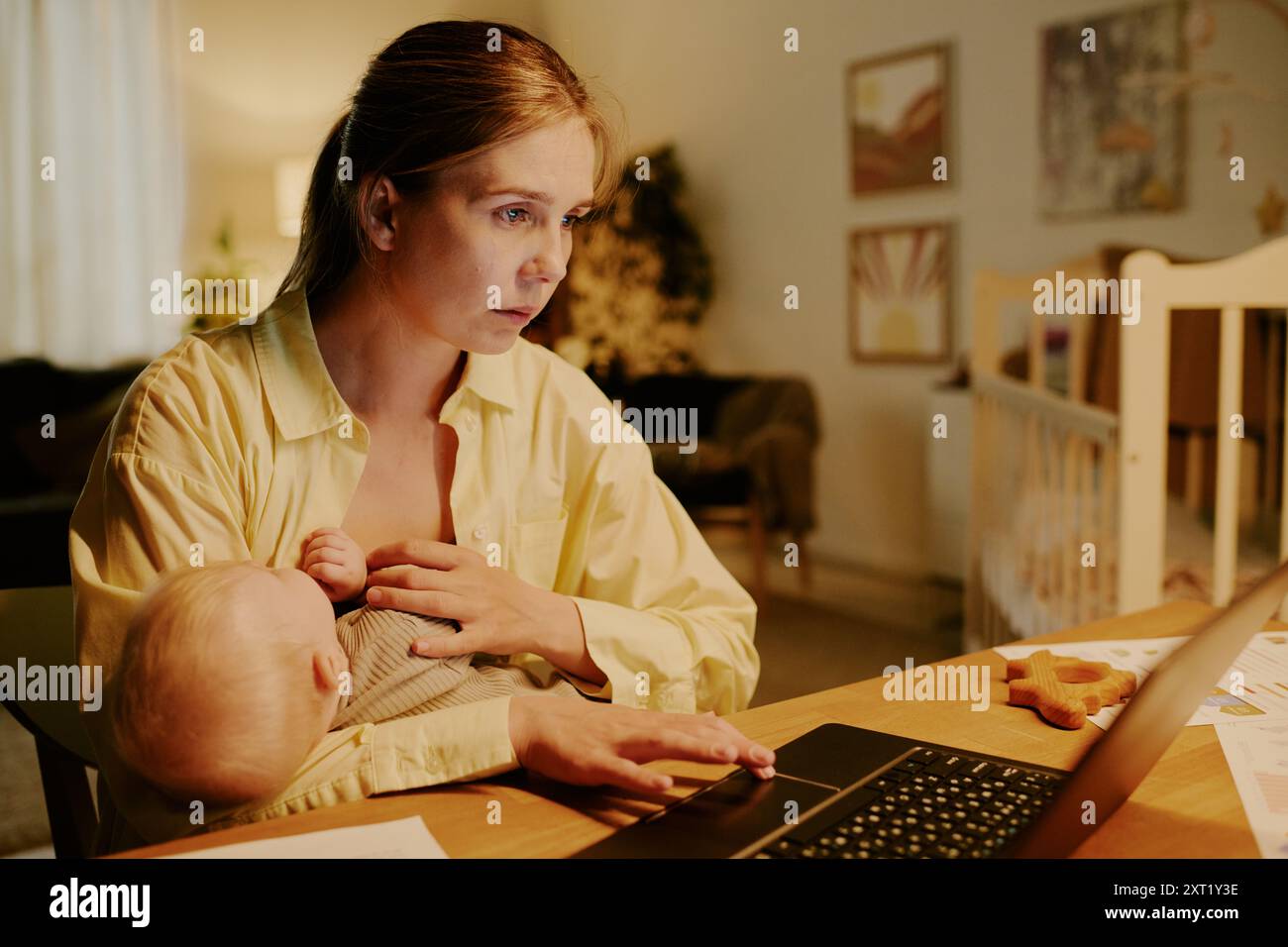 Mother Working from Home While Nursing Baby Stock Photo