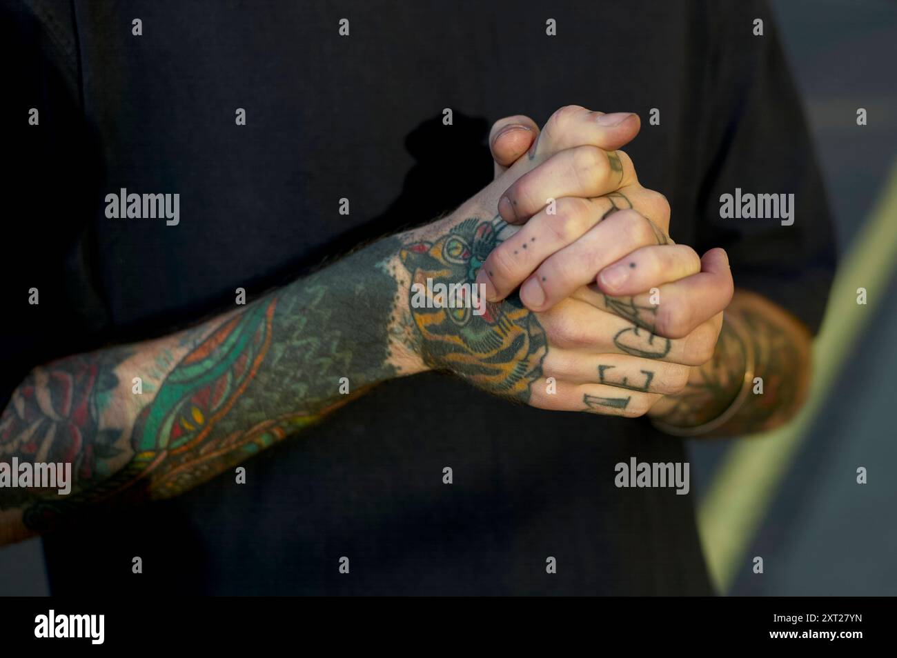 Close-up of a person s clasped hands showing intricate tattoo designs on the forearms. bola02829 Copyright: xConnectxImagesx Stock Photo