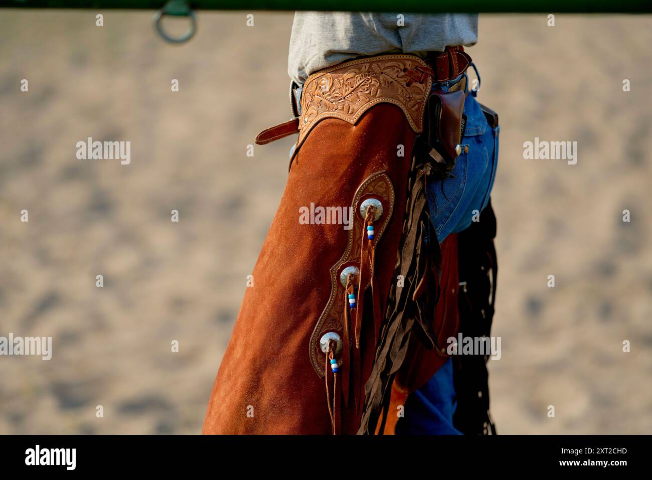 Close-up of a cowboy wearing a leather chaps and denim jeans standing in a sandy arena. bola03075 Copyright: xConnectxImagesx  RECORD DATE NOT STATED Stock Photo