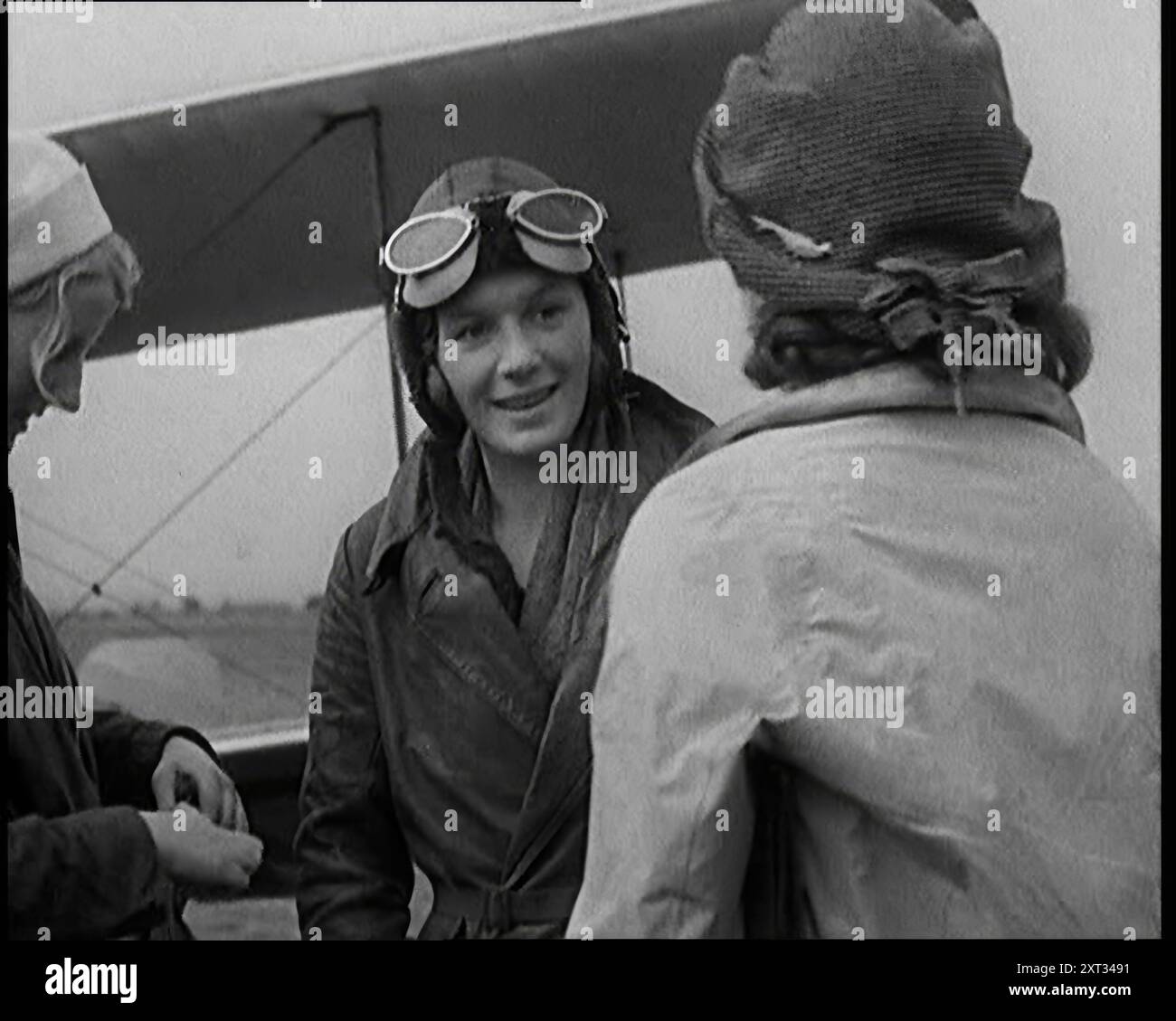 Two Female Civilians About to Pilot a Plane, 1931. 'As travelling at high speed seemed to be the first recreation of the new age, Sally Smith [ie the average British woman] had to get into that too. Well, if Amy Johnson could build her own plane, fly it, and service it, why shouldn't Sally? Even in the thirties there were still plenty of places to fly to, and in the process, break a record and win yourself a newspaper prize of say, &#xa3;10,000, so nobody could complain it wasn't worth a candle'. From &quot;Time To Remember -  A New Era&quot;, 1931 (Reel 2); documentary about the world in the Stock Photo