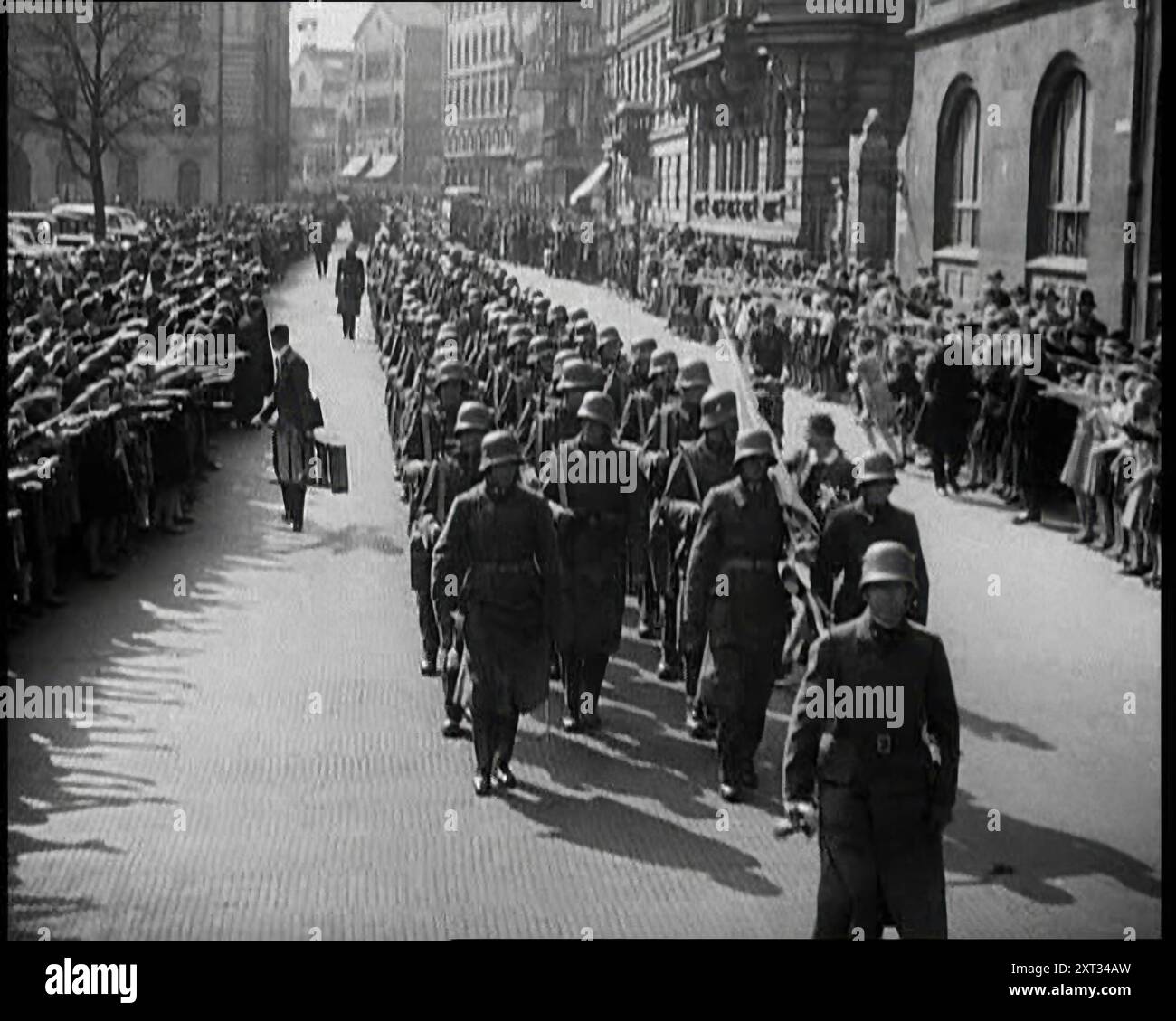 Crowd Watching German Soldiers Marching Down a Street Towards the Camera, 1930s. From &quot;Time To Remember -  The Powers That Were&quot;, 1930s (Reel 3); a documentary about various important figures of the 1930s. Stock Photo