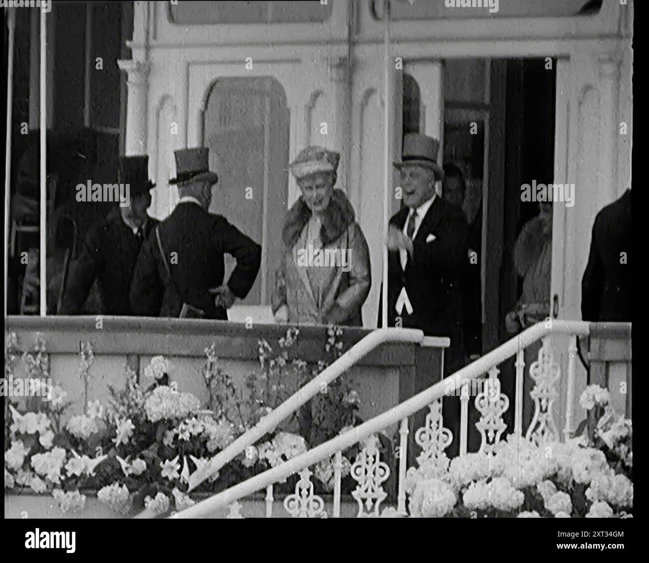 King George V and Queen Mary of Teck in the Royal Box at Ascot Race Course, 1931. 'At Ascot [horse races] the crowds as always, the show of fashion, the moment of splendour. At such functions you would find, of course, the royal family, King George V and Queen Mary'. From &quot;Time To Remember -  A New Era&quot;, 1931 (Reel 4); documentary about the world in the early 1930s. Stock Photo