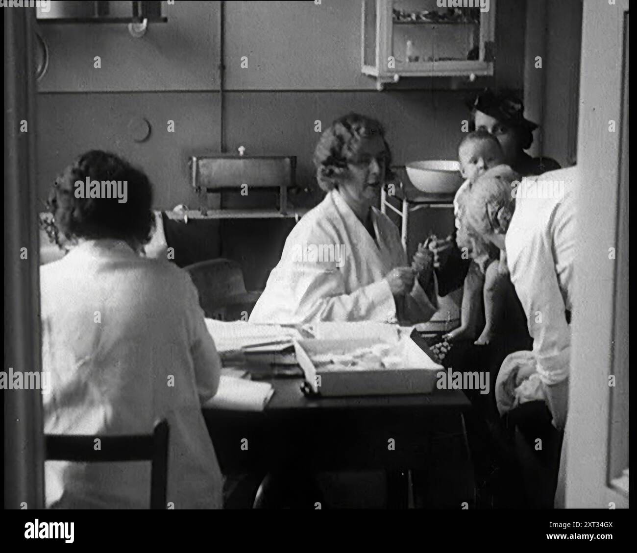 Female Civilians and Their Babies at Health Clinics Where the Babies Are Checked by Female Nurses, 1931. Britain during the Great Depression. 'Misfortune brings unity, and there, in the depressed areas, by unselfish communal effort, they learned much about living with one's neighbour, much about trying and working, what we now blithely accept, as the welfare state'. From &quot;Time To Remember -  A New Era&quot;, 1931 (Reel 4); documentary about the world in the early 1930s. Stock Photo