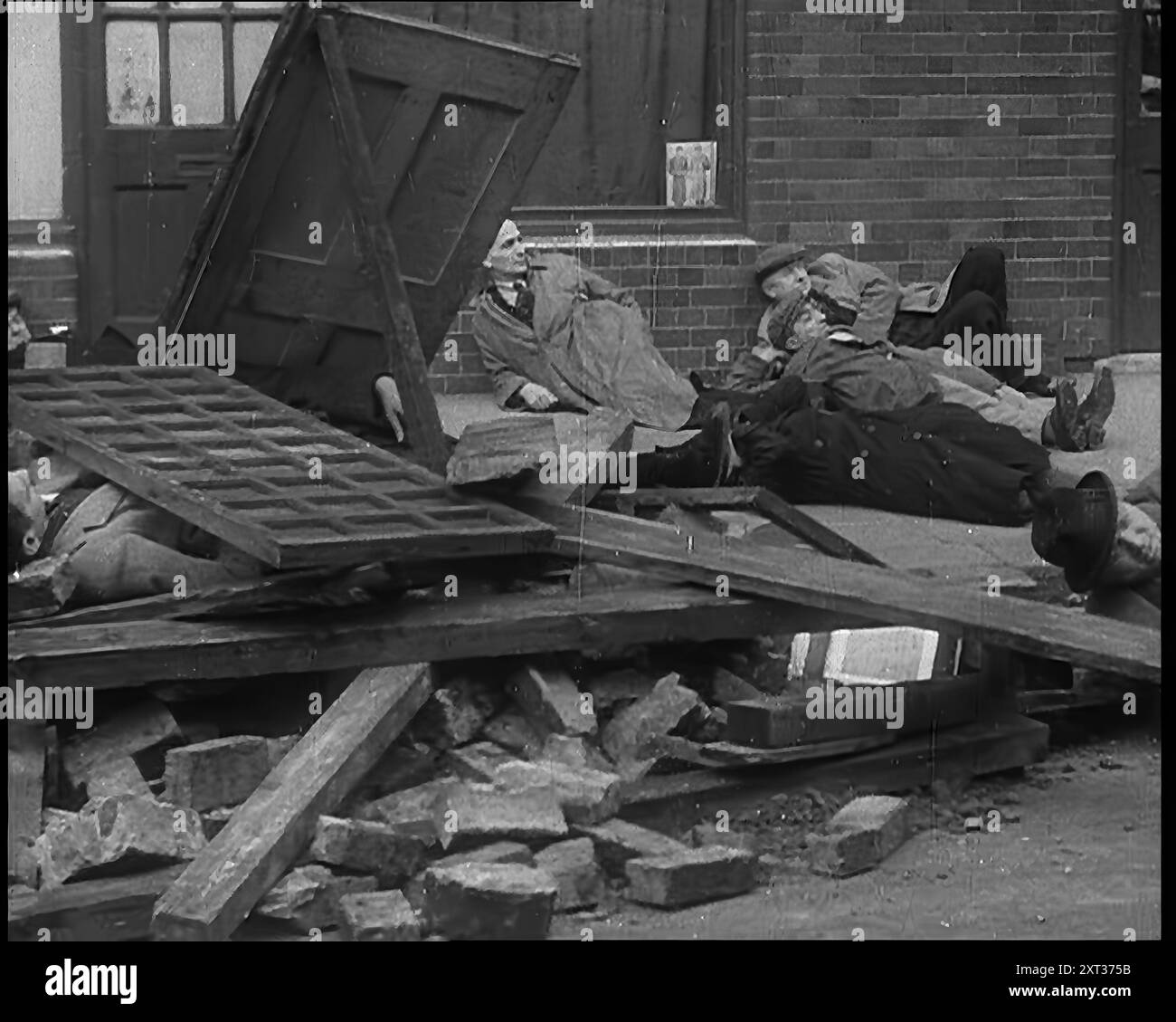 British People Acting Out Bomb attacks and Crashed German Planes, Lying Under Rubble, 1940. Second World War. 'A Britain intensely conscious of her duty, but as yet neither geared to it, nor fully aware of its full implications. Air raid precautions, yet no air raids. Yet out of these crude beginnings was forged a civil defence organisation second to none'. From &quot;Time To Remember -  Run Rabbit Run&quot;, 1940 ( Reel 2); documentary film about events of early months of 1940. Stock Photo