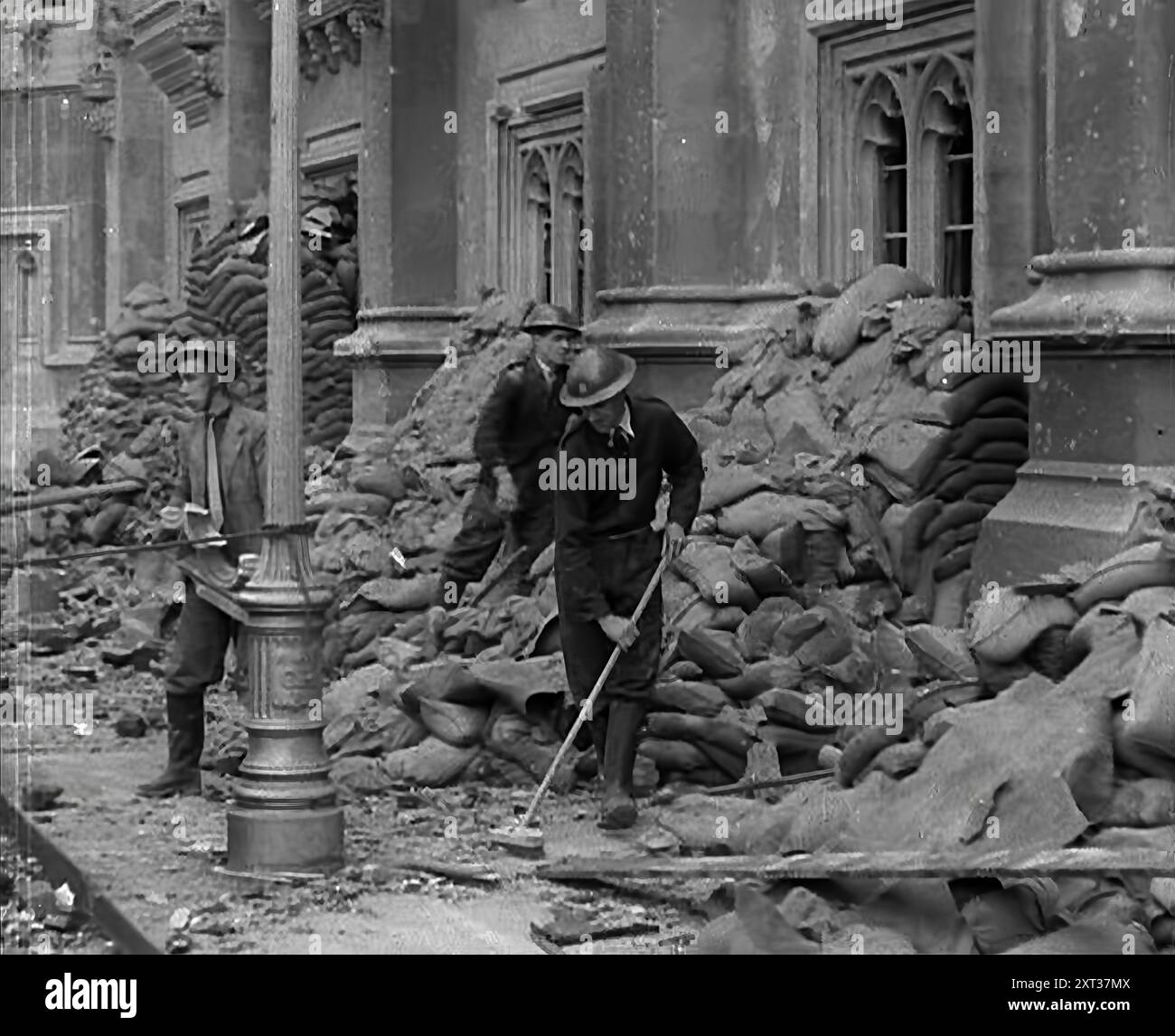 British Air Raid Wardens Clearing up Rubble Around the Palace of Westminster, London, 1941. Second World War. 'Britain...knew all about war with Nazi Germany. By now she was quite used to the &quot;business as usual&quot; tags, the improvisation, the making-do in the streets'. From &quot;Time To Remember - Operation Barbarossa&quot;, 1941 (Reel 1); documentary film about events of 1941, on the Eastern Front and at Pearl Harbour. Stock Photo