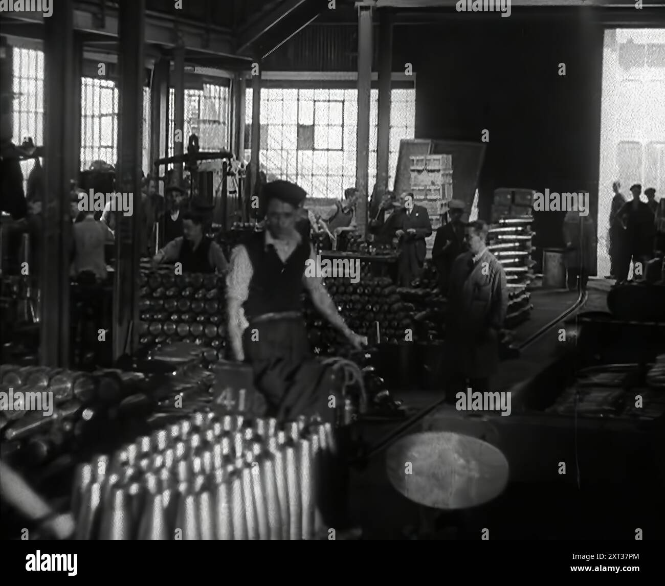 British Factory Workers Making Ammunition, 1941. Second World War. As well as American aid, the munitions '...pouring from Britain's factories provided Hitler with even more reason for pursuing Operation Barbarossa. Britain's output now could only mean stalemate in the West for Germany, unless she could find other sources of manpower and supply'.From &quot;Time To Remember - Operation Barbarossa&quot;, 1941 (Reel 1); documentary film about events of 1941, on the Eastern Front and at Pearl Harbour. Stock Photo