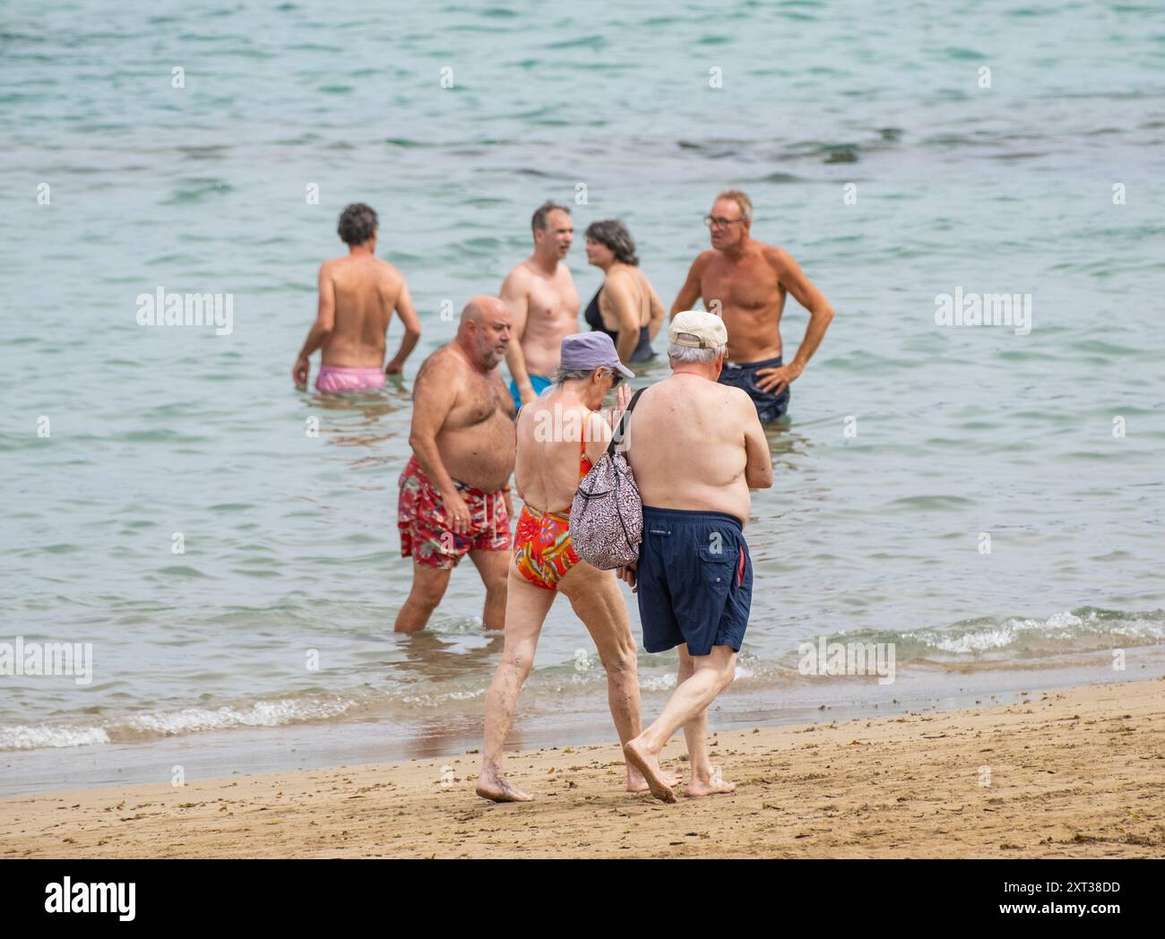 Gran Canaria, Canary Islands, Spain, 13th August 2024. Tourists, many British, trying to keep cool on the city beach in Las Palmas. Temperatures reached 39 degrees Celsius inland on Gran Canaria on Monday. Credit: Alan Dawson/Alamy Live News. Stock Photo