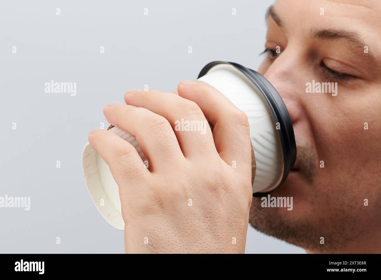 Paper cup in man hand front view isolated on white studio background ...