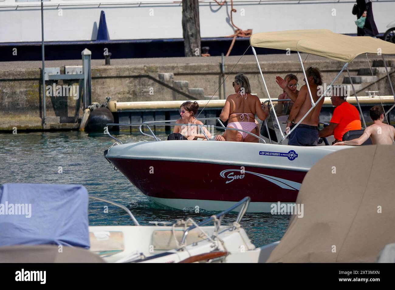 Fiume Mincio, Peschiera del Garda. 13th August 2024. Heatwave conditions persisted across much of Europe today, including Lake Garda and surrounds in Northern Italy. Daytime temperatures were expected to reach 37 degrees Celsius in the shade today. People trying to stay cool at Peschiera del Garda, on the south side of Lake Garda, in Northern Italy. Credit: james jagger/Alamy Live News Stock Photo