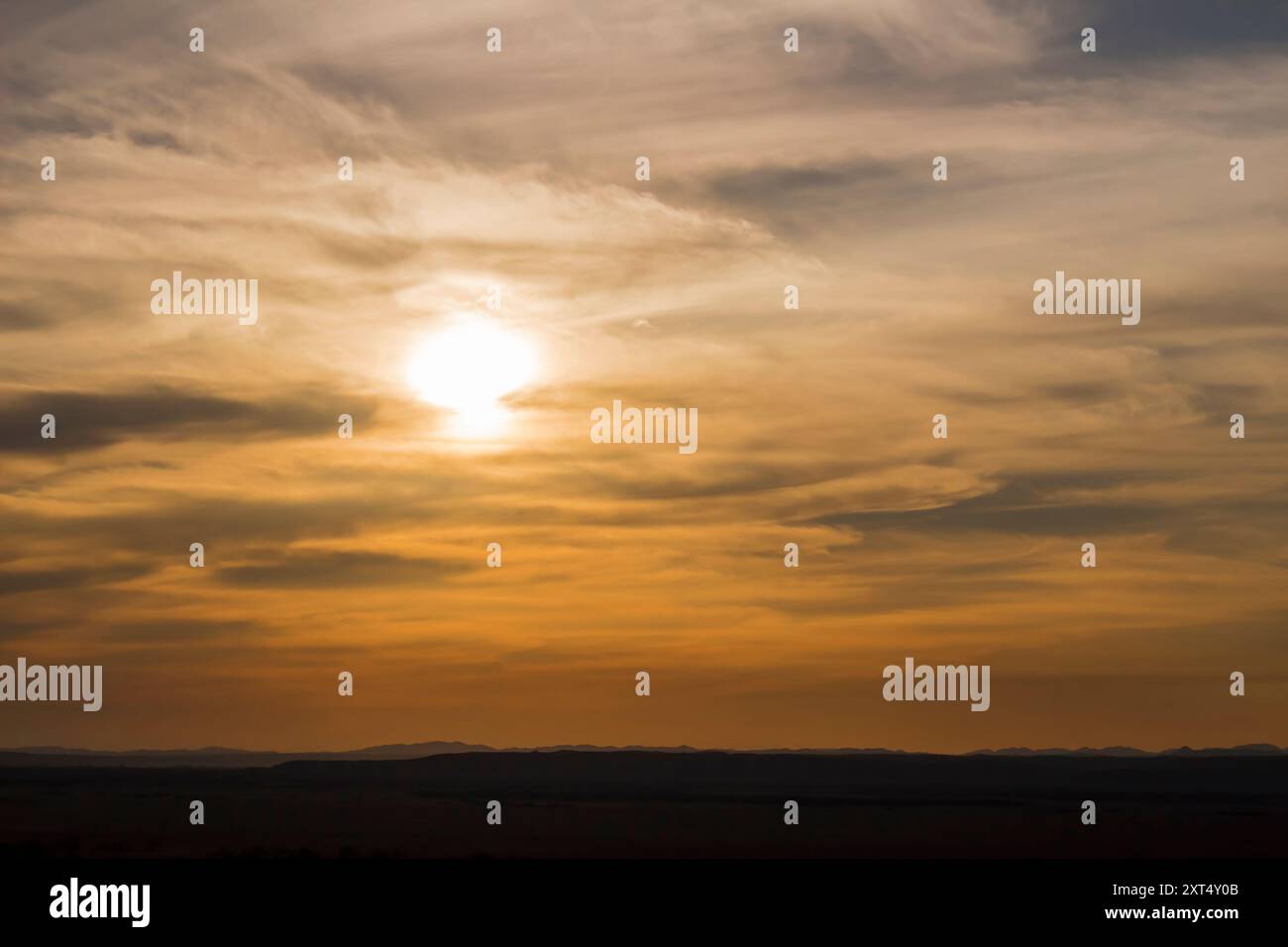Sunset sky and the sun setting in thin clouds Stock Photo - Alamy