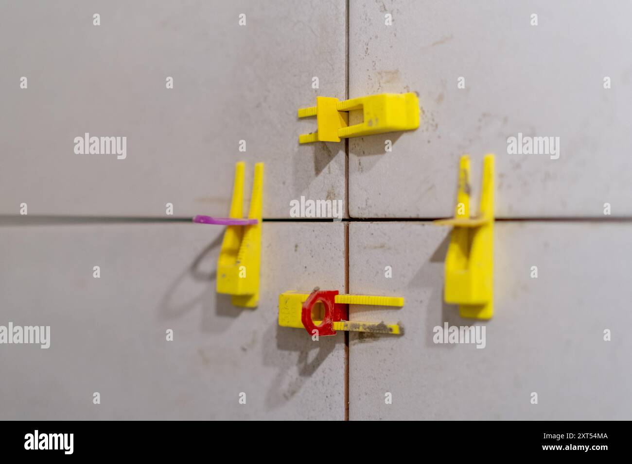 Tile leveling system with plastic clips and wedges in action. Ensures precise Stock Photo