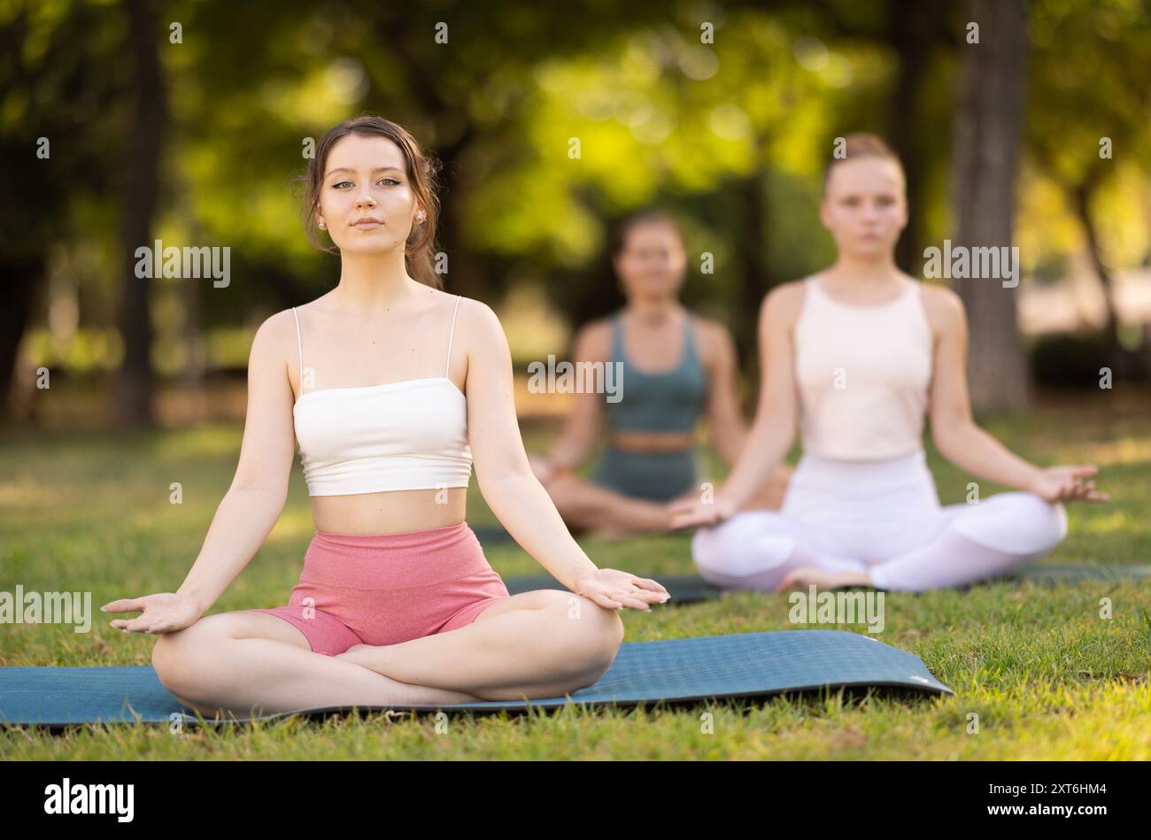 Lotus pose - young pretty girls doing yoga outdoors Stock Photo - Alamy