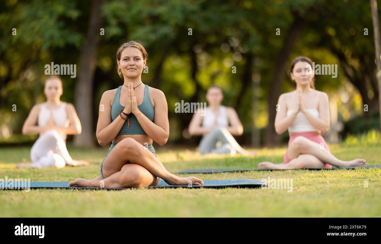 Lotus pose - young pretty girls doing yoga outdoors Stock Photo - Alamy