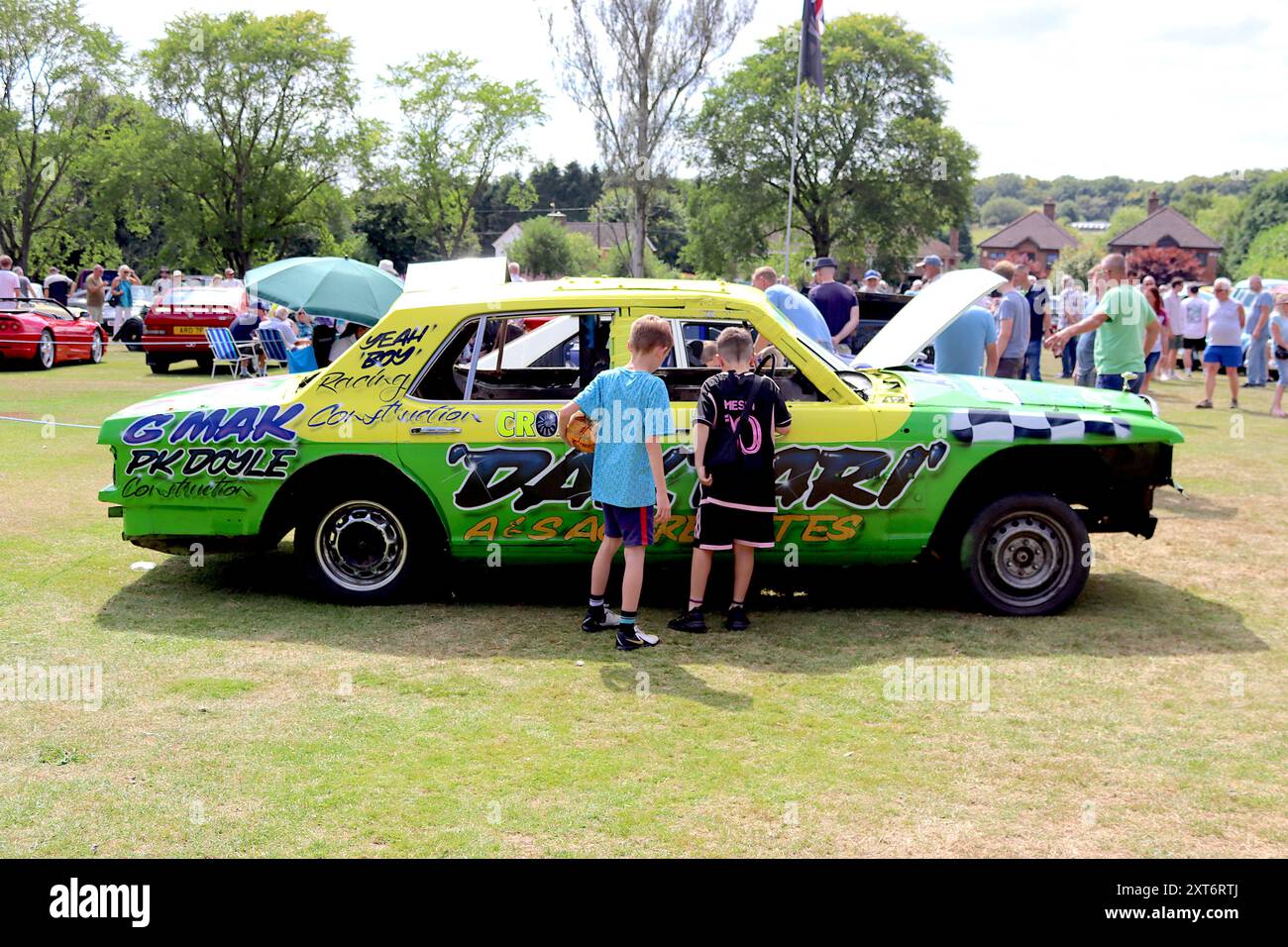 Two inquisitive young boys peer inside a Rolls Royce/Bentley SZ series stripped out, painted and signwritten ready for its finale - banger racing. Stock Photo