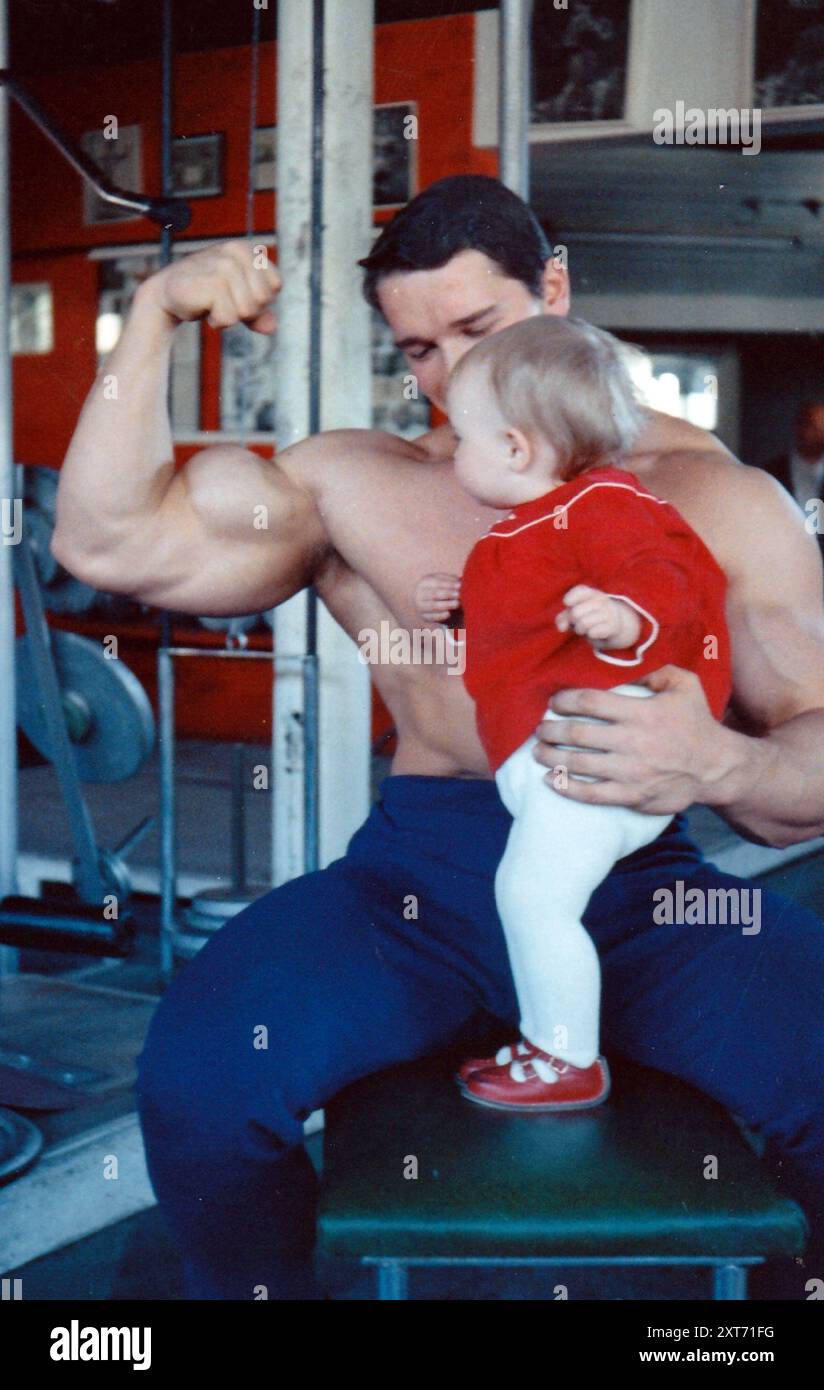 HOLLYWOOD LEGEND ARNOLD SCHWARZENEGGER WITH A YOUNG ADMIRER AT BOB WOOLGAR'S GYM IN PORTSMOUTH WHEN HE WAS TRAINING FOR THE MR. UNIVERSE COMPETION,1966 PIC MIKE WALKER 1966 Stock Photo