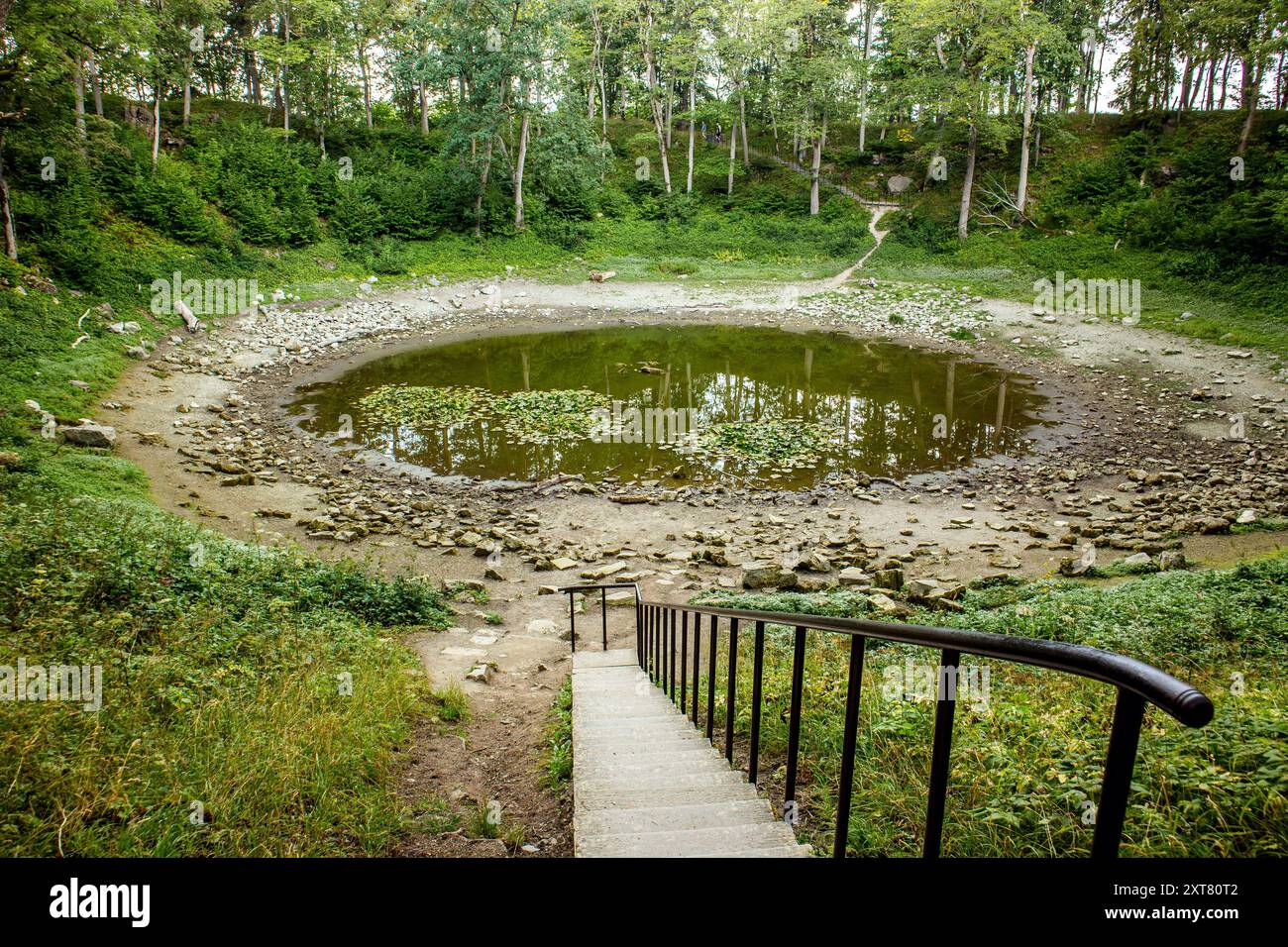 Kaali meteorite crater on Saaremaa island in 2024. Round lake in summer, surrounded with trees. Estonia. Stock Photo