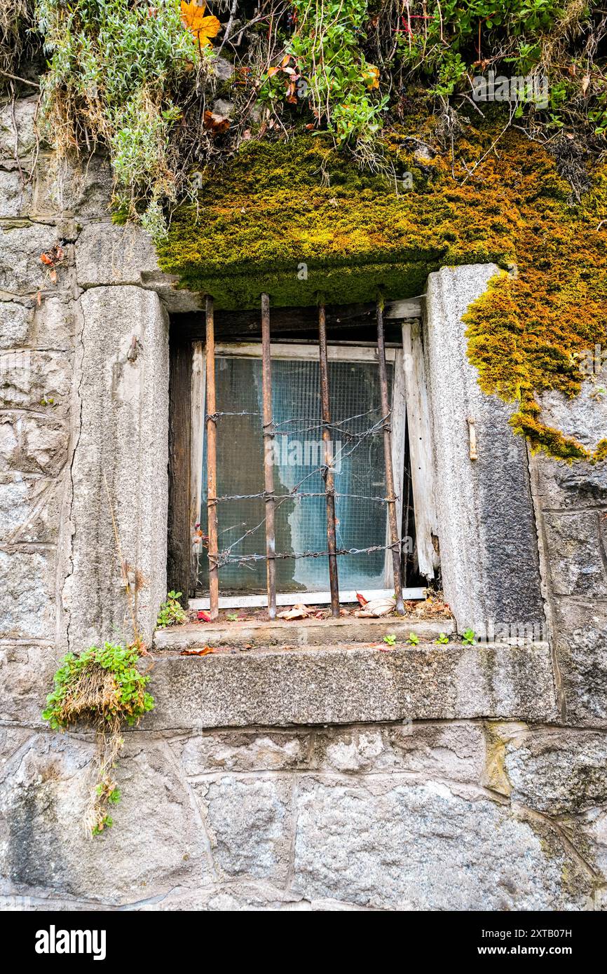 Old window with a grille on a stone house. Stock Photo