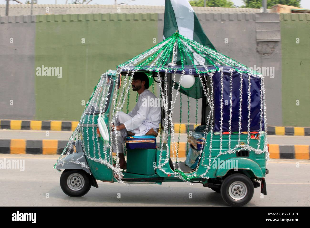 A driver decorates his ricksha with national flag colors to celebrate ...