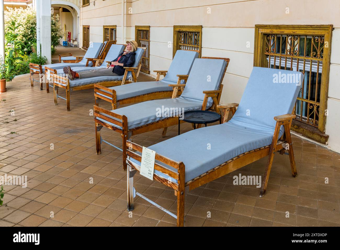 Lying on these original wooden loungers was the central element of tuberculosis treatment in Swiss sanatoriums such as the Schatzalp in Davos between around 1870 and 1950, based on the assumption that lying quietly for hours in the fresh, cool and pure mountain air strengthens the body's self-healing powers and has a favourable effect on the course of the disease. The former Schatzalp sanatorium above Davos is now a hotel. Thomas-Mann-Weg, Davos, Grisons, Switzerland Stock Photo