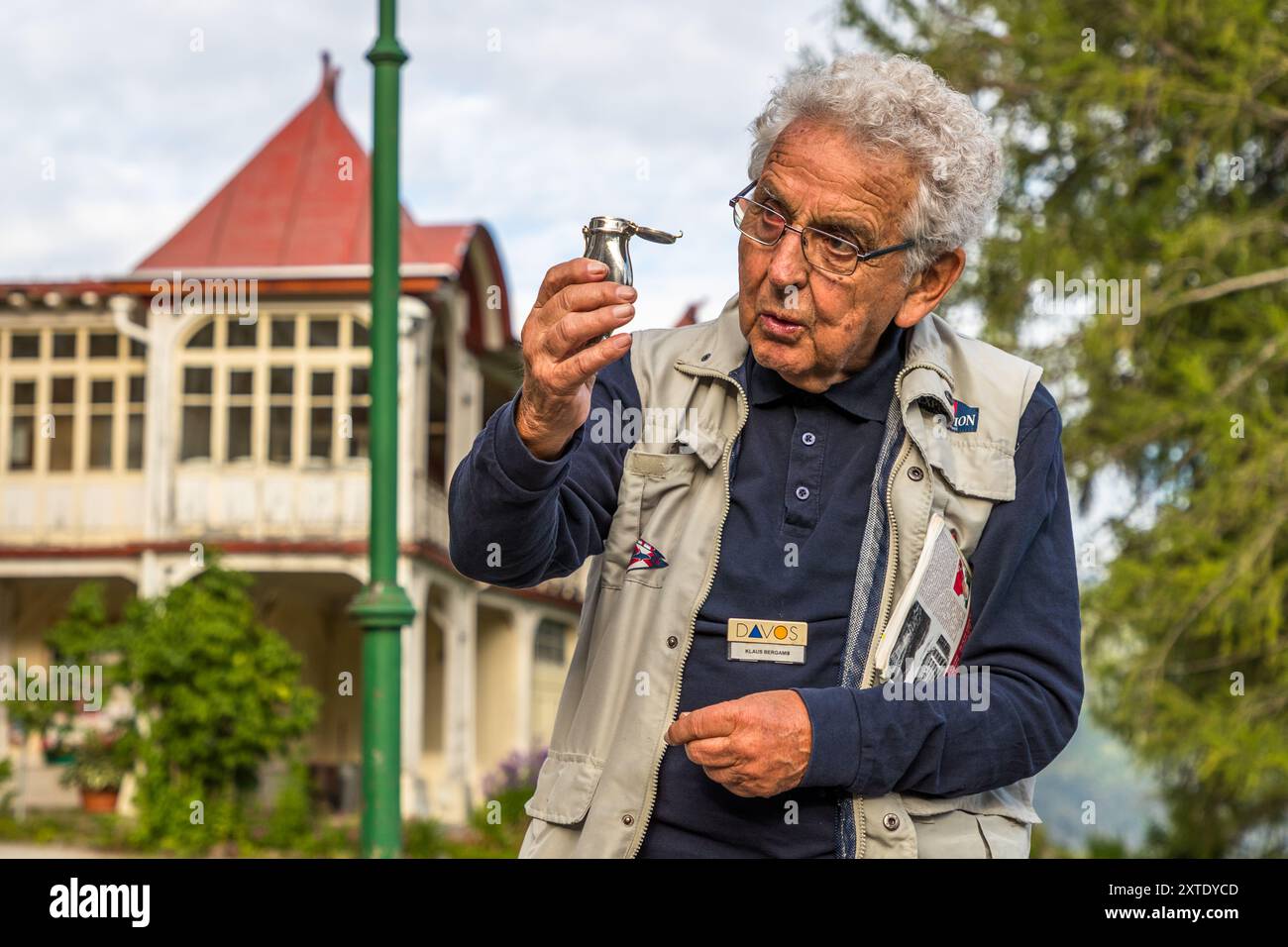 Tour guide Klaus Bergamin explains the use of a pocket spittoon that tuberculosis patients always carried with them. The former Schatzalp sanatorium is now a hotel. Thomas-Mann-Weg, Davos, Grisons, Switzerland Stock Photo