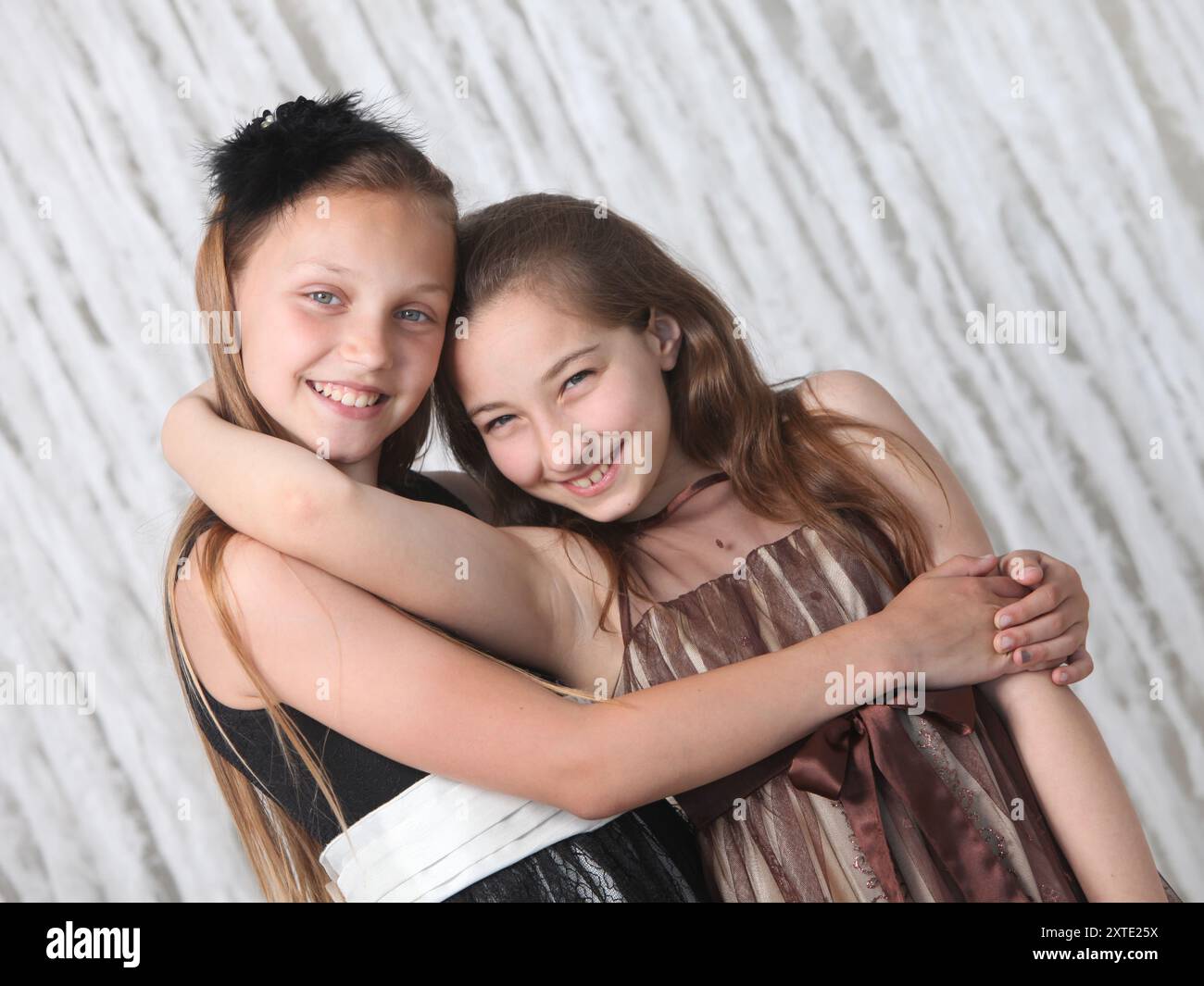portrait of two pretty cheerful preteen girls in elegant dresses on ...