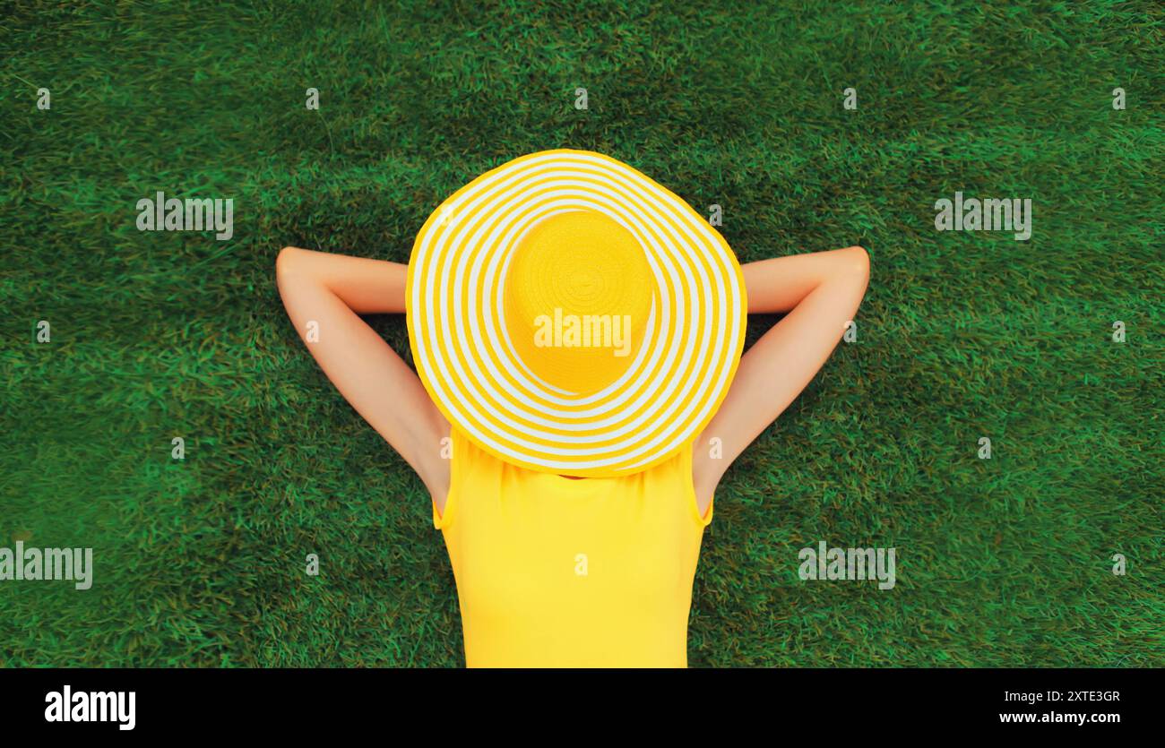 Happy relaxing girl with straw hat covering her face lies on green ...