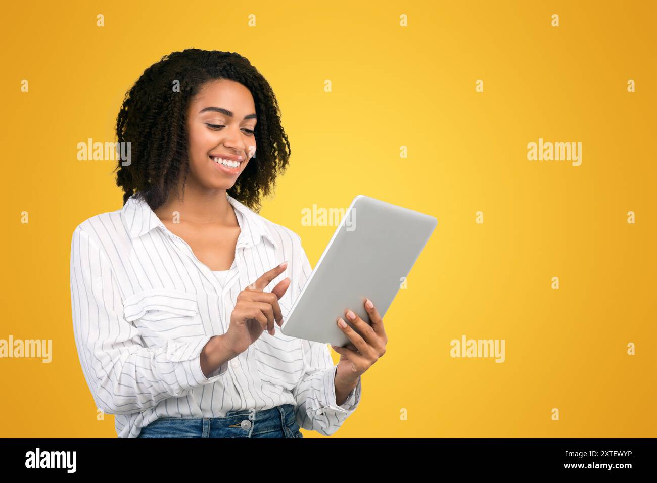 Smiling afro woman reading email on digital tablet Stock Photo