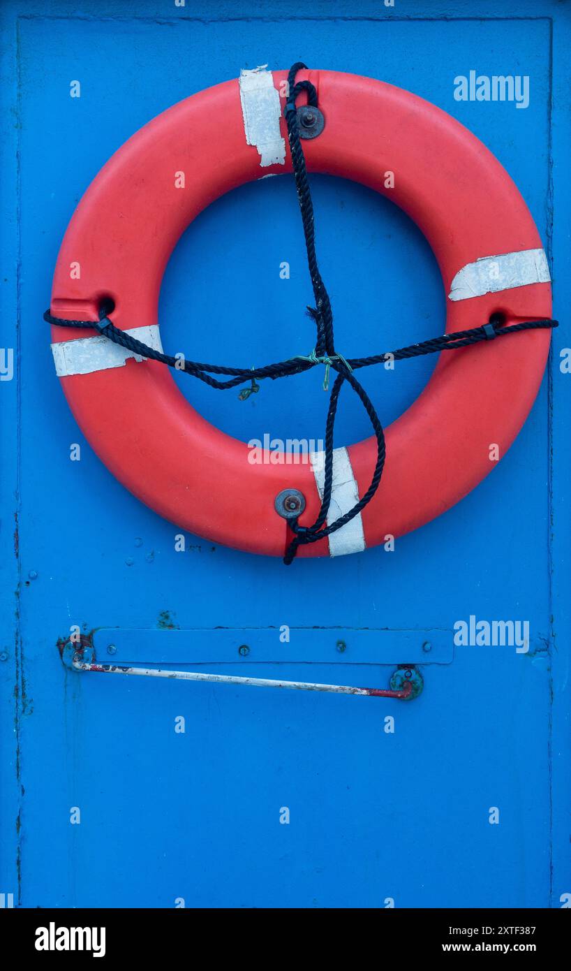 Red lifebelt on blue door Stock Photo