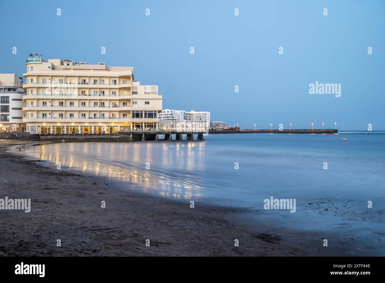 Peaceful evening beachfront view of Hotel Medano, El Medano, with reflections, in Granadilla de Abona, Tenerife, Canary Islands. Stock Photo