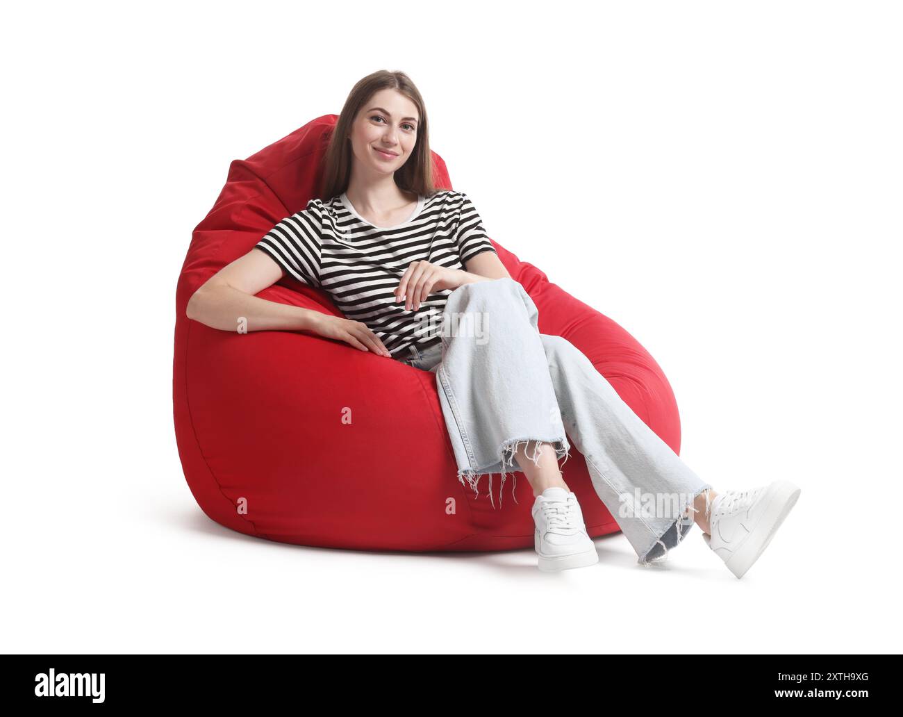 Beautiful young woman sitting on red bean bag chair against white ...
