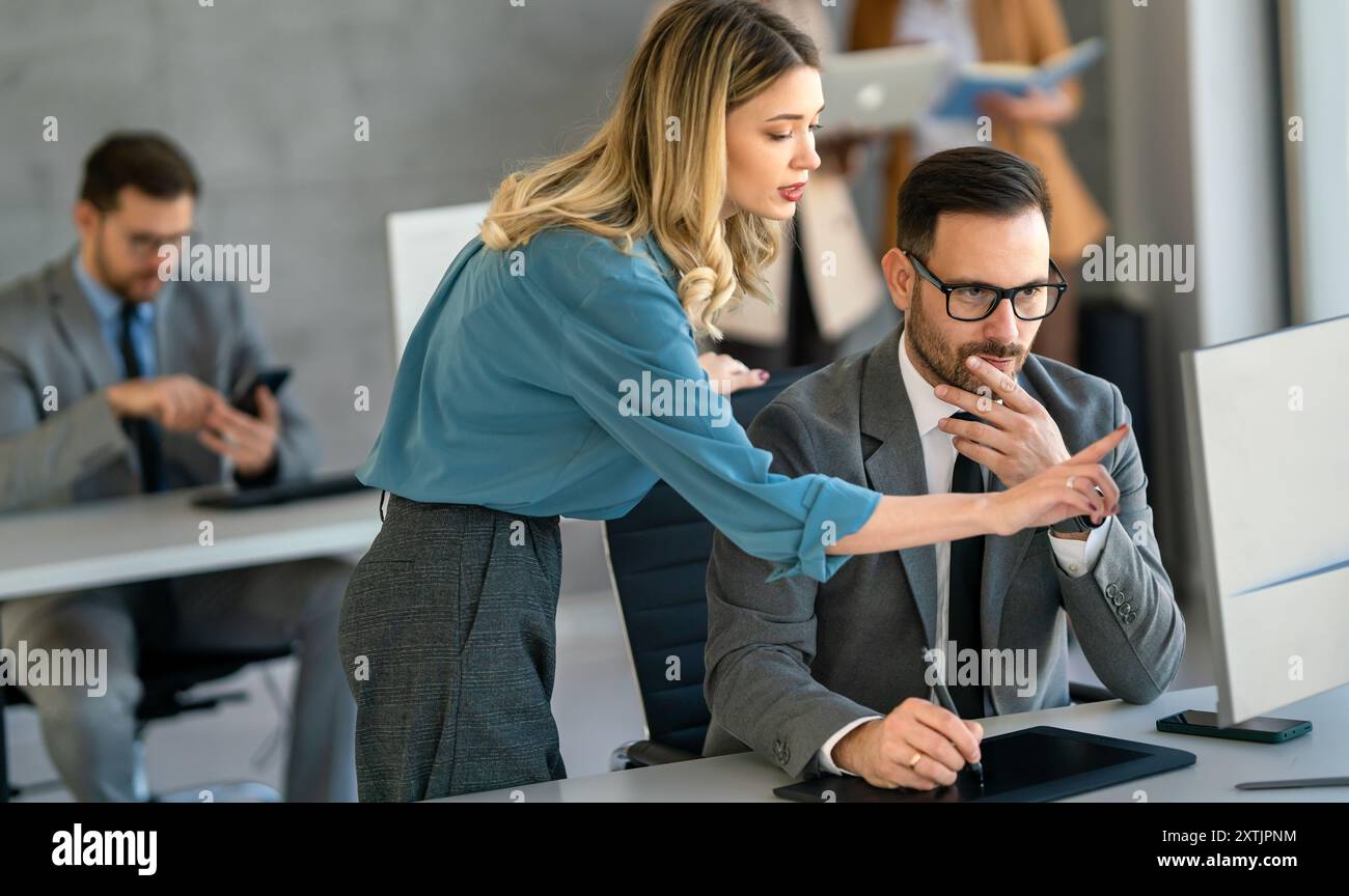 Group of multiethnic business people analyzing data using computer while working in the office Stock Photo