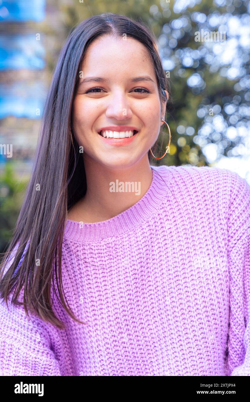 Vertical portrait young latin woman smiling confident standing at street. Stock Photo