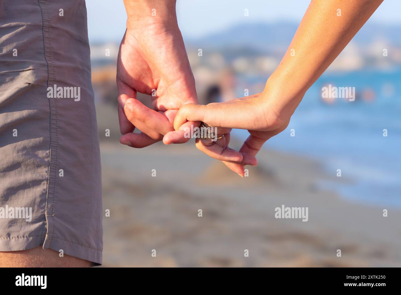Unrecognizable couple holding hands looking at the sea Stock Photo - Alamy