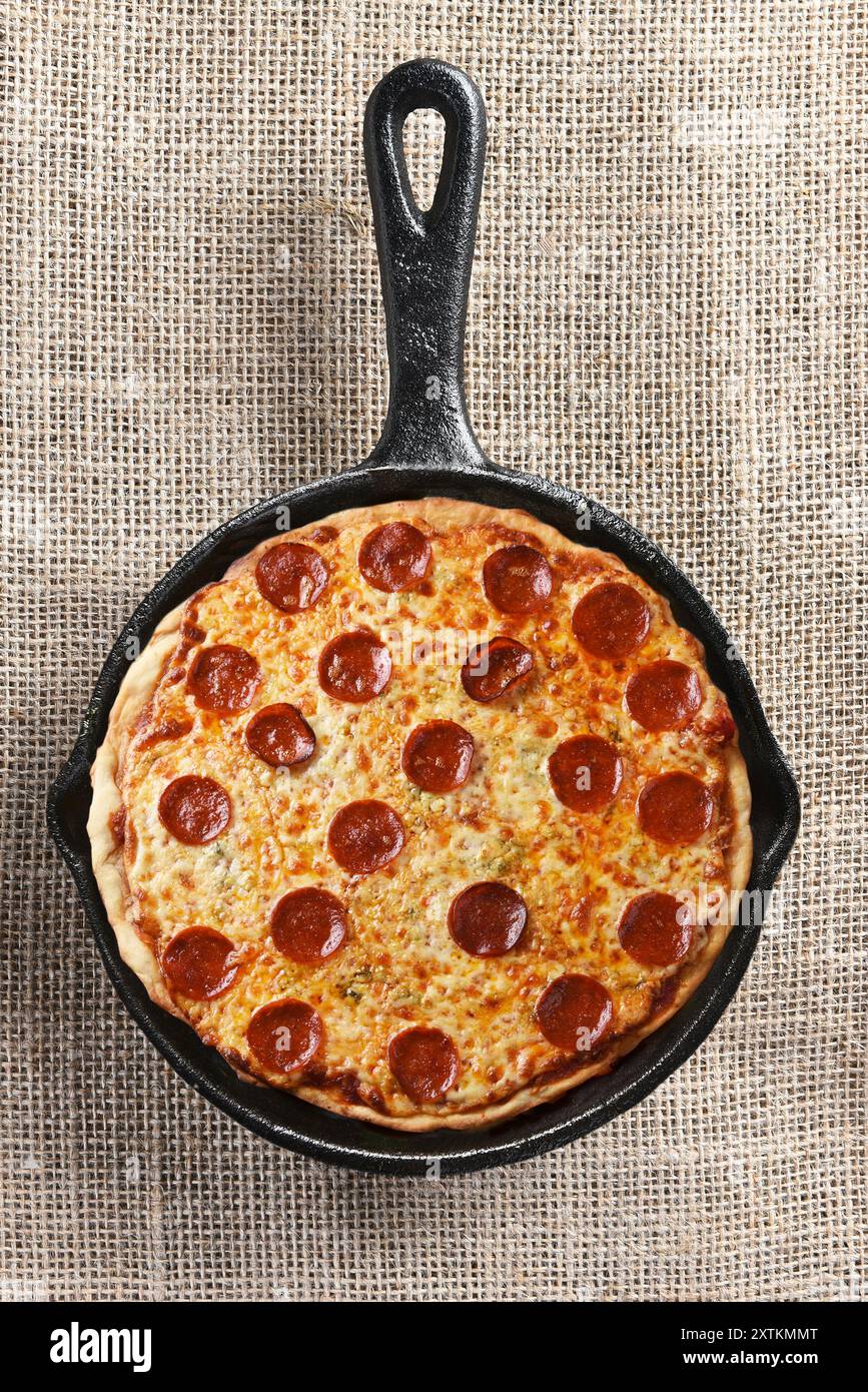 High angle shot of cheese and pepperoni pizza in a cast iron skillet. Stock Photo