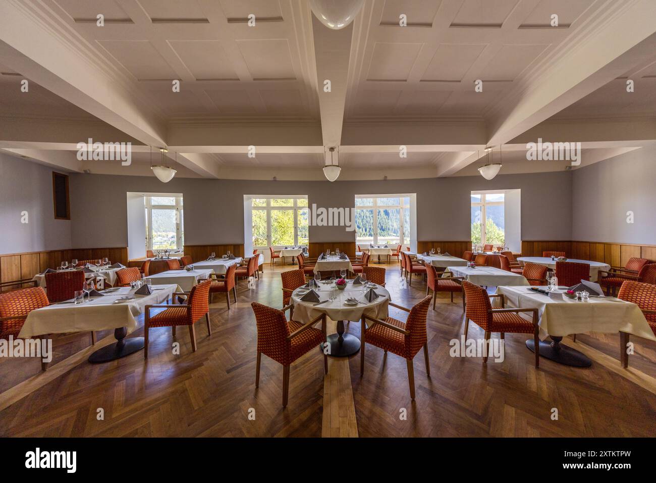 Dining room in today's Waldhotel, formerly the Waldsanatorium, where Katia Mann stayed in 1912 for treatment of a catarrh of the tip of the eye. Thomas Mann visited her here. The dining room could have been the inspiration for a description in the novel The Magic Mountain. At the Waldhotel Davos, which used to be called the Waldsanatorium. It owes its fame to Katja Mann. Thomas Mann's wife cured her lung disease there. Buolstrasse, Davos, Grisons, Switzerland Stock Photo