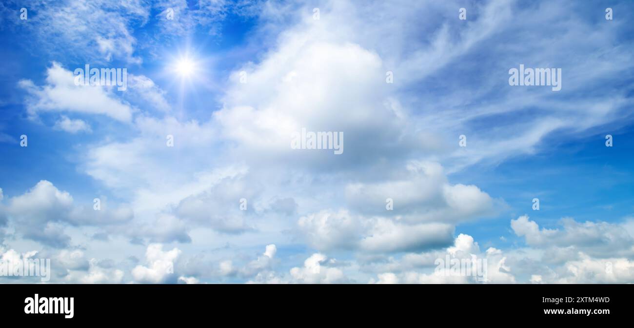 Blue sky with white clouds and bright sun. Wide photo Stock Photo - Alamy