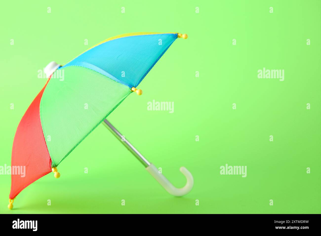 Mini colorful umbrella on green background Stock Photo