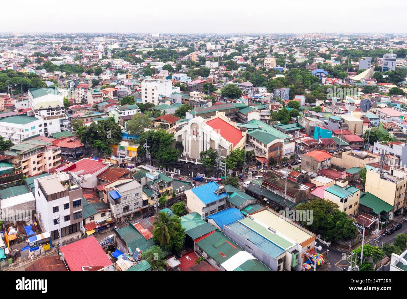 Urban landscape and sprawl of residential commercial buildings and a church in Quezon City Philippines Stock Photo