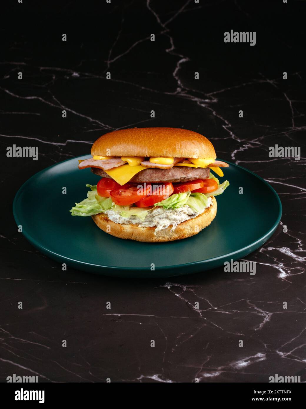 burger with sauce, cheese, vegetables and bacon Stock Photo