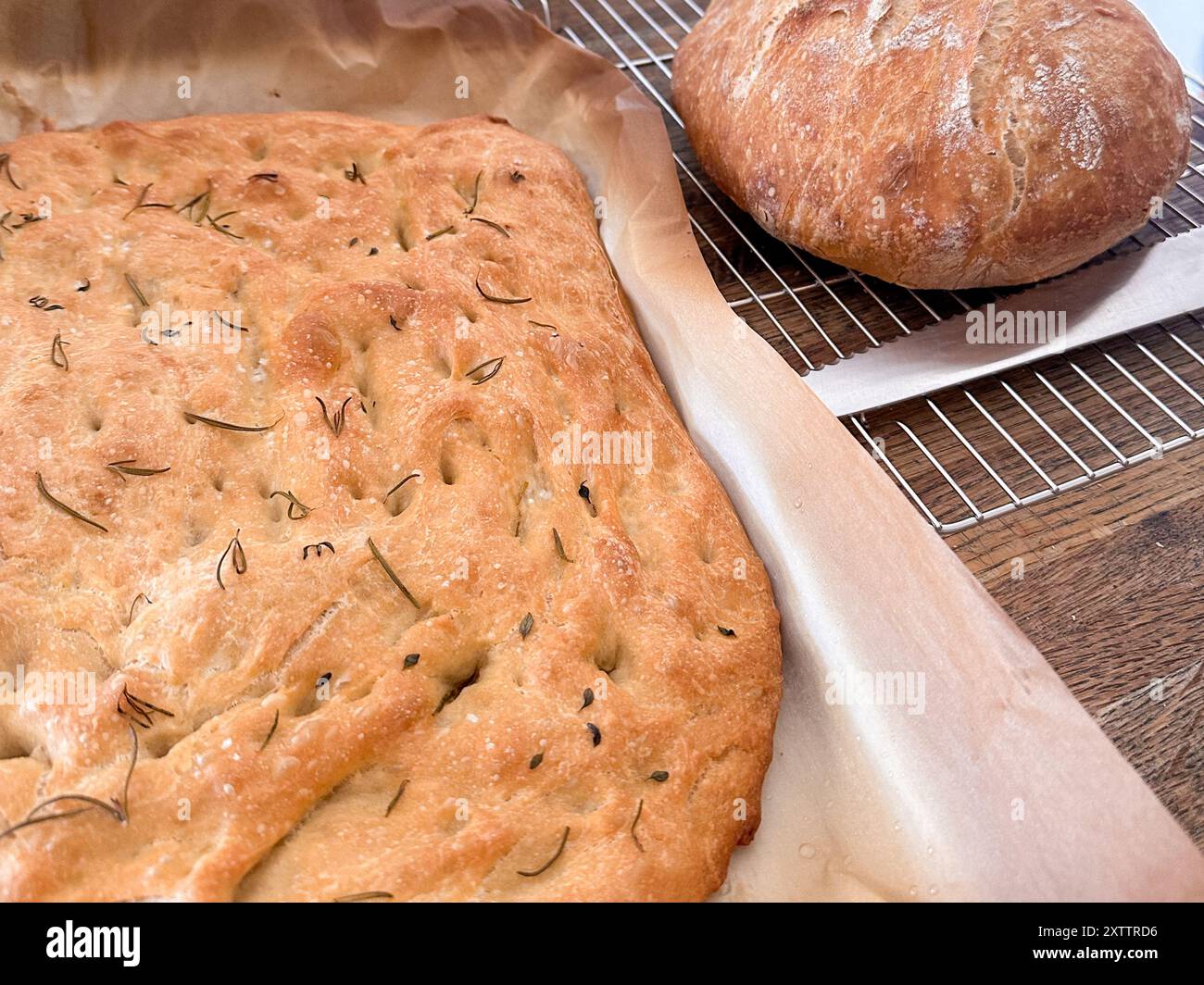 Freshly baked focaccia and round loaf cooling on a wire rack Stock Photo