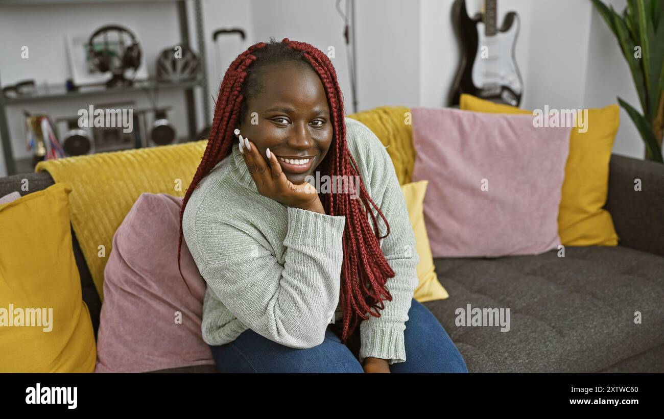 Beautiful african woman with braids smiling in a cozy living room ...