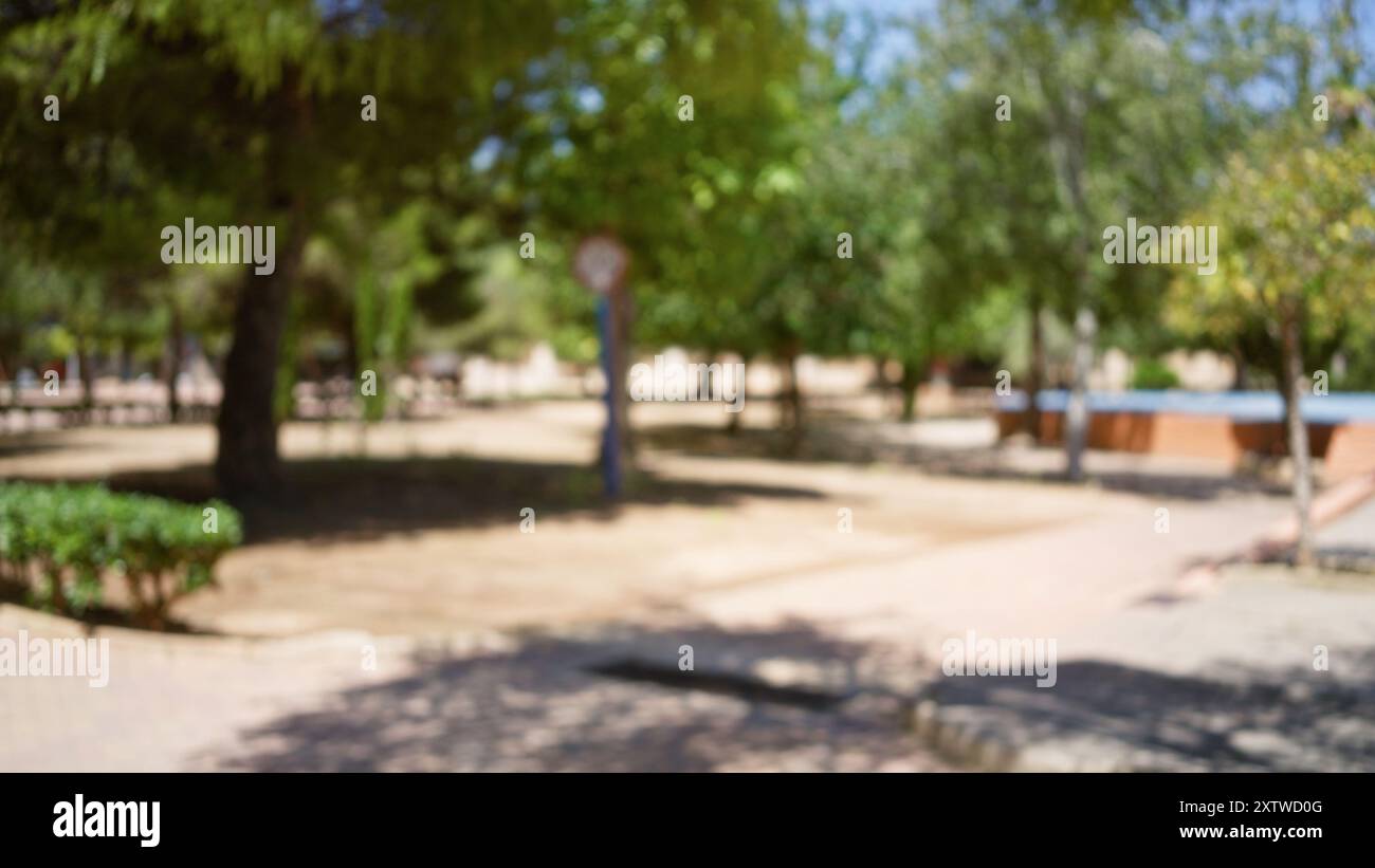 Blurred outdoor scene of a park with trees, pathways, and greenery ...