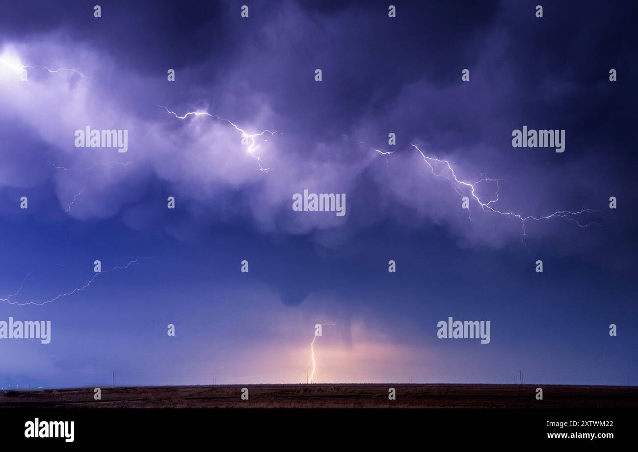 Lightning bolts illuminate the night sky above a flat landscape Stock ...