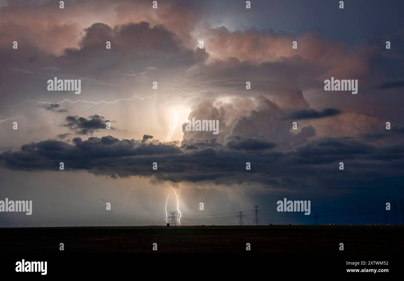 A thunderstorm illuminates the sky with a powerful lightning strike ...