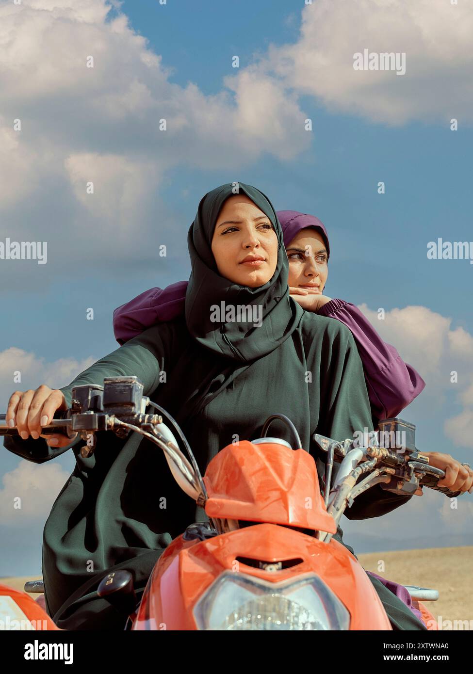 Two women in hijabs riding a motor scooter under a clear sky Stock ...