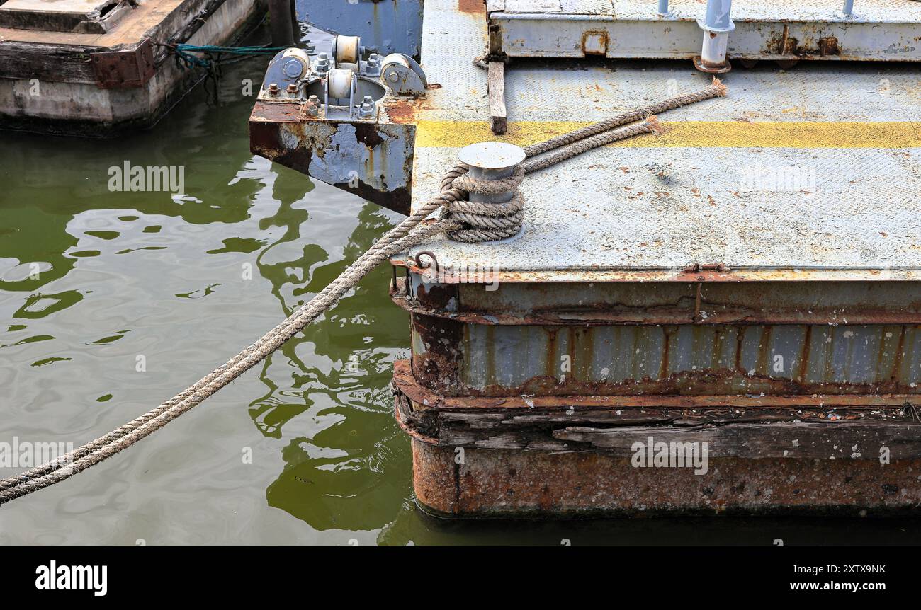 Bollard with Mooring line on rusty pier referred to a post on a ship or quay. Stock Photo