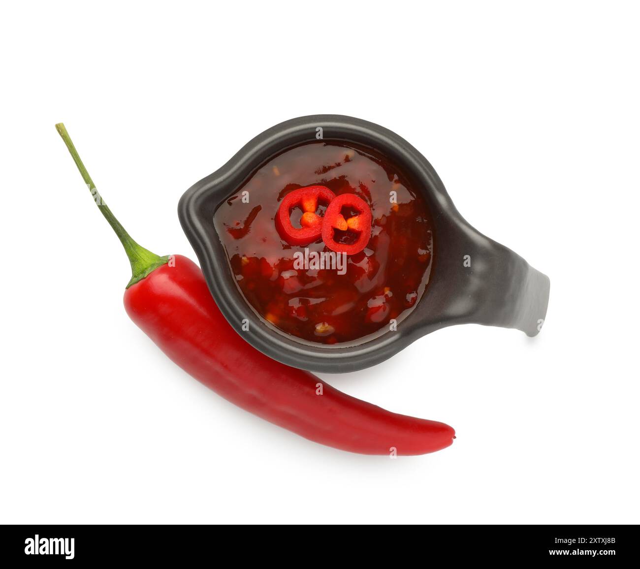 Hot chili sauce in gravy boat and pepper isolated on white, top view Stock Photo