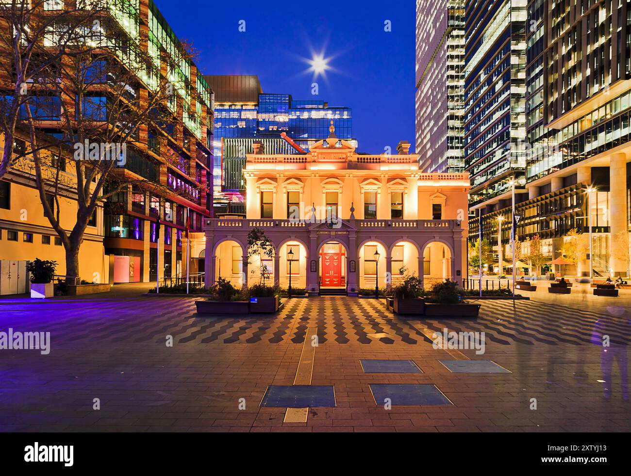 Historic Town Hall building in Parramatta city CBD surrounded by tall high-rise towers at sunset under full moon. Stock Photo